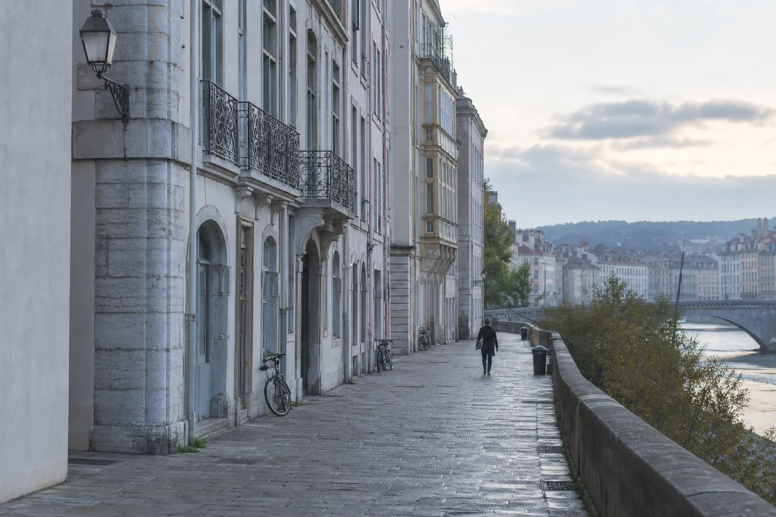 Rue calme au bord de la Saône à Lyon, façades en pierre claire, lumière grise du matin